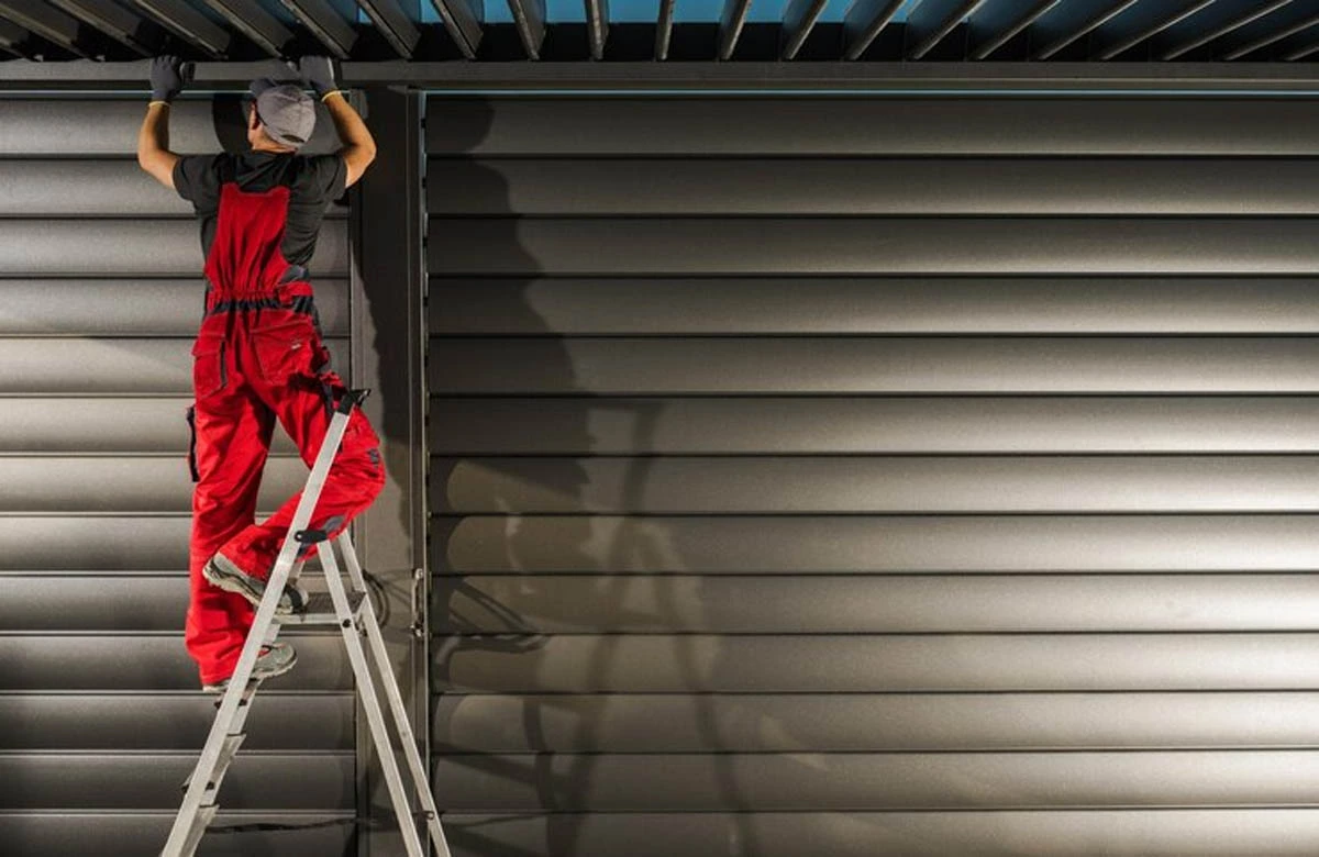 A specialist on a ladder performs detailed garage door spring replacement, ensuring reliable operation and maximum safety.